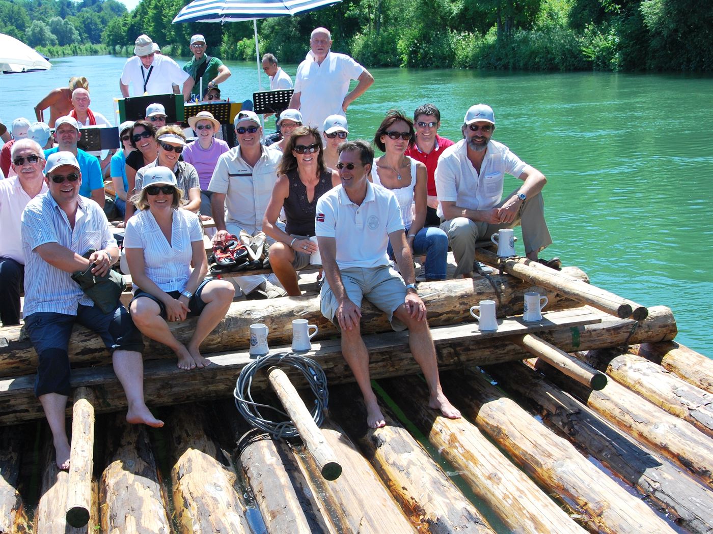 Lachende Gruppe auf einem Floß mit Blaskapelle auf der Isar